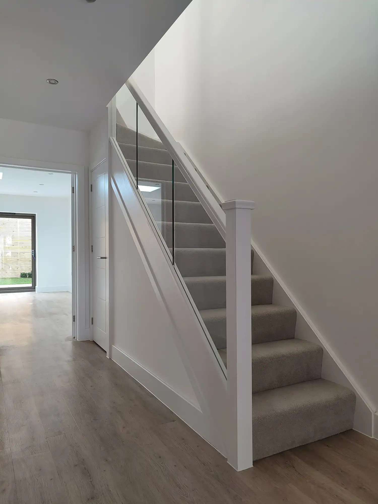 grey carpeted stairs with wooden flooring