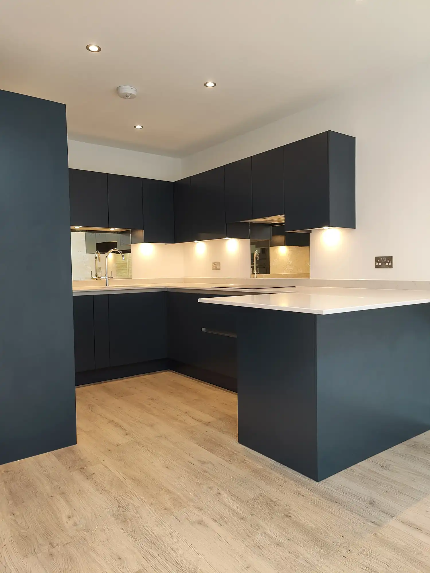 dark blue kitchen with wood flooring