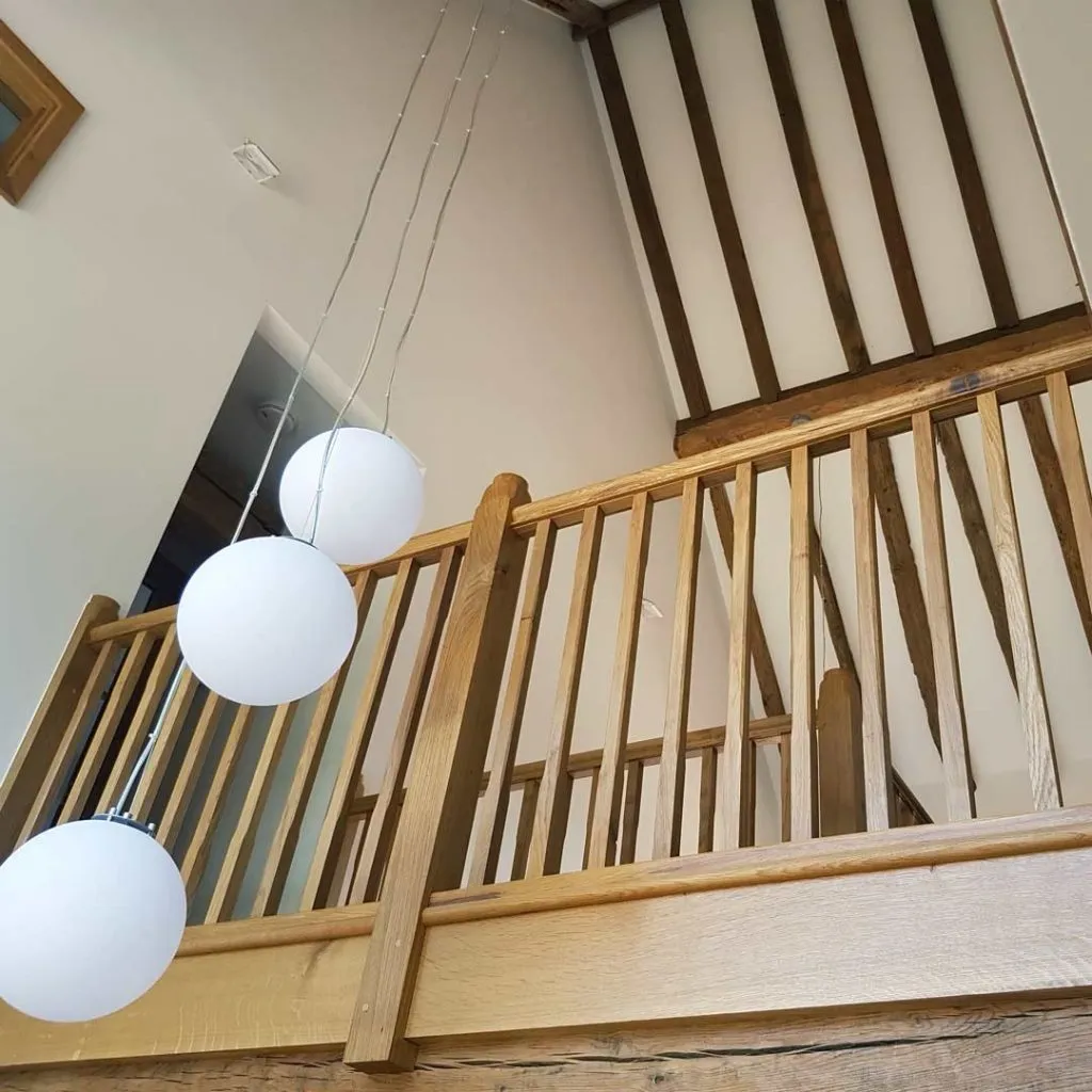 oak stairs with white lights hanging from the ceiling
